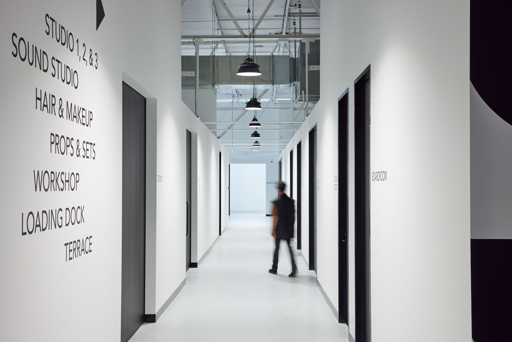 indoors, architecture, building, person, corridor, hallway, clothing, coat